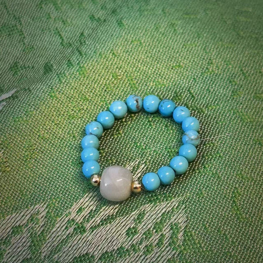 Feng Shui-inspired handmade ring with turquoise beads and a central jade stone, designed for balance and energy flow